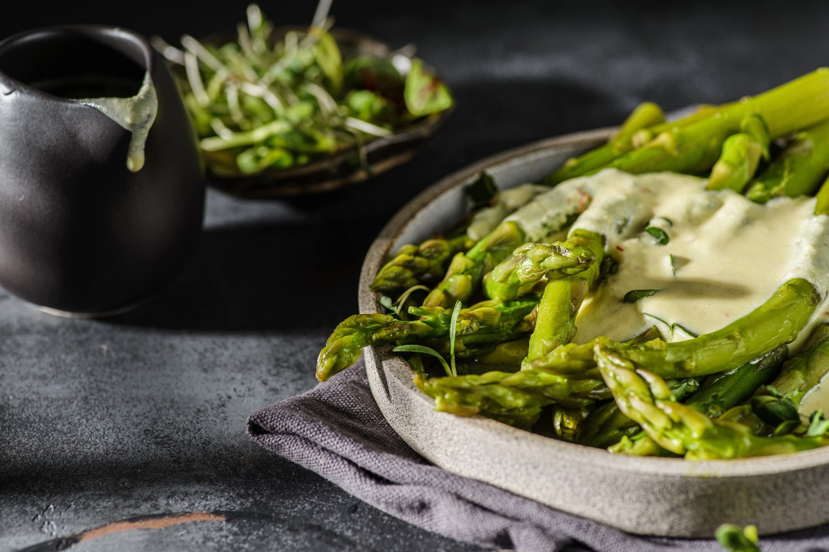 Piatto con asparagi serviti con salsa a base di uova e senape