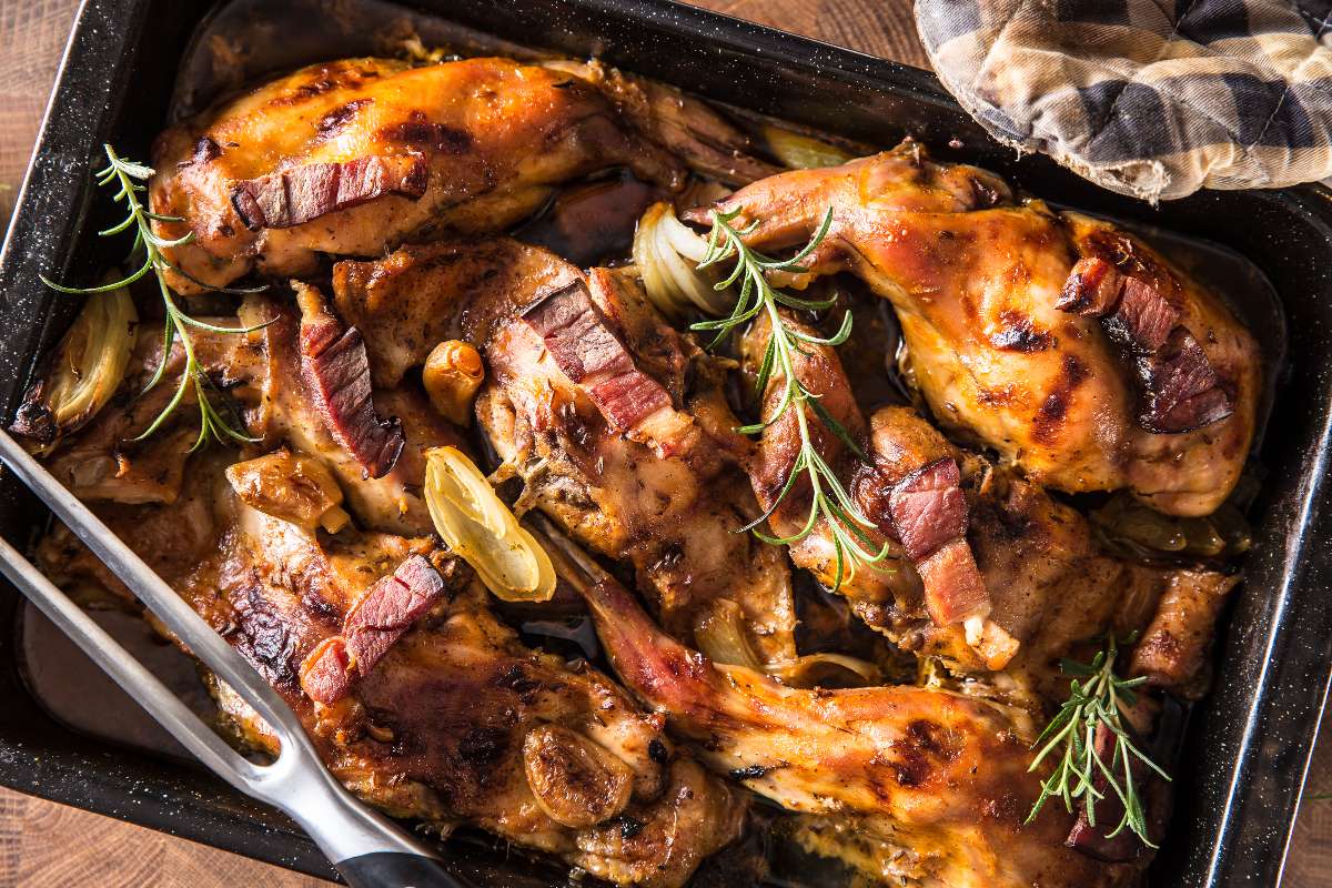 Vista dall'alto coniglio a pezzi cotto al forno con aglio e rosmarino