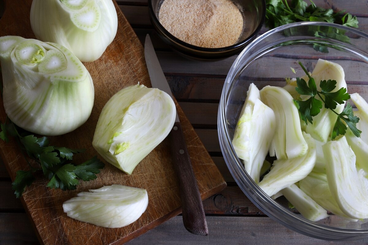 Pulizia finocchi su tagliere di legno con ciotola