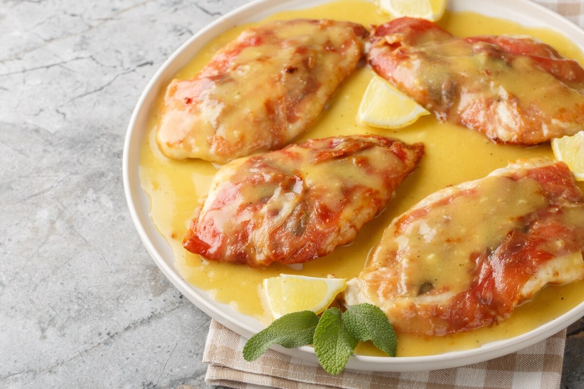 Piatto di petto di pollo con prosciutto e formaggio fuso