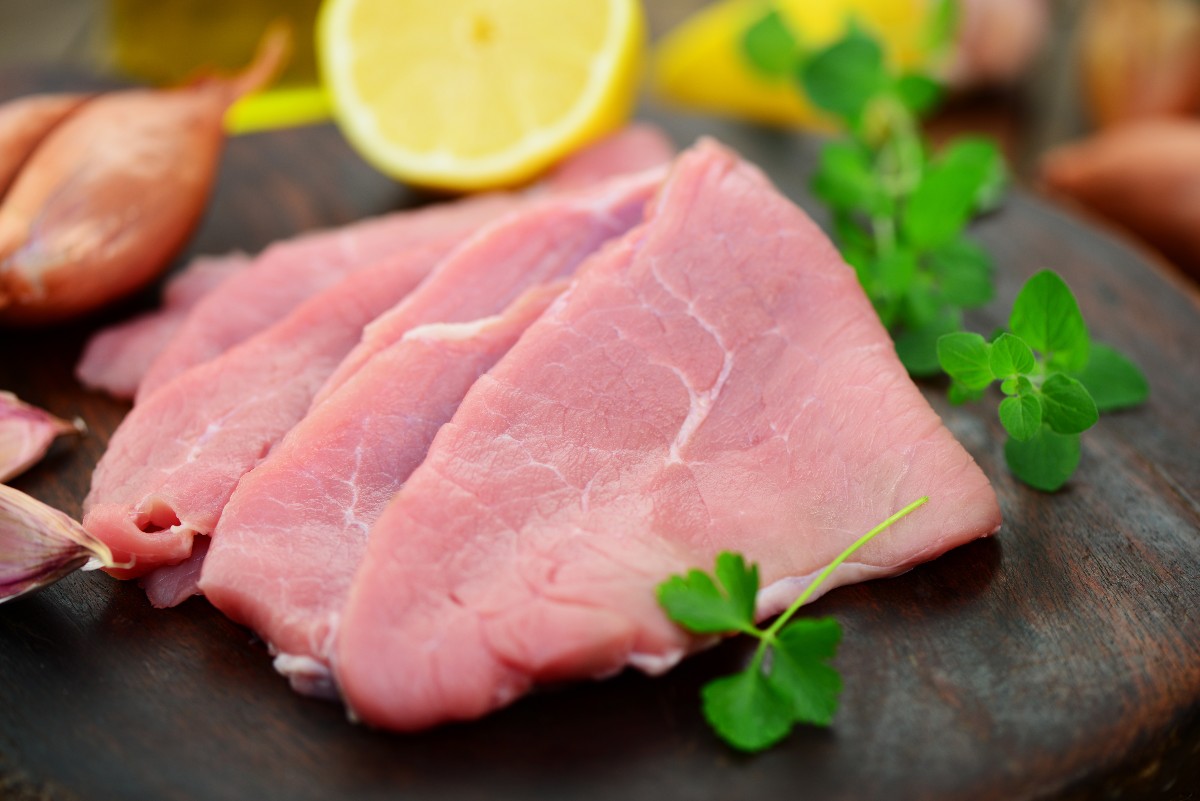 Tagliere con scaloppine di carne tagliate sottili