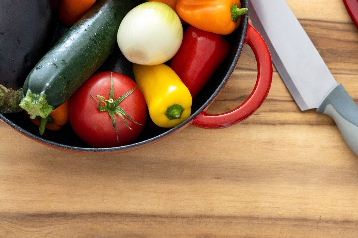 Verdure fresche estive (zucchine, pomodori, cipolle, peperoni) in contenitore 