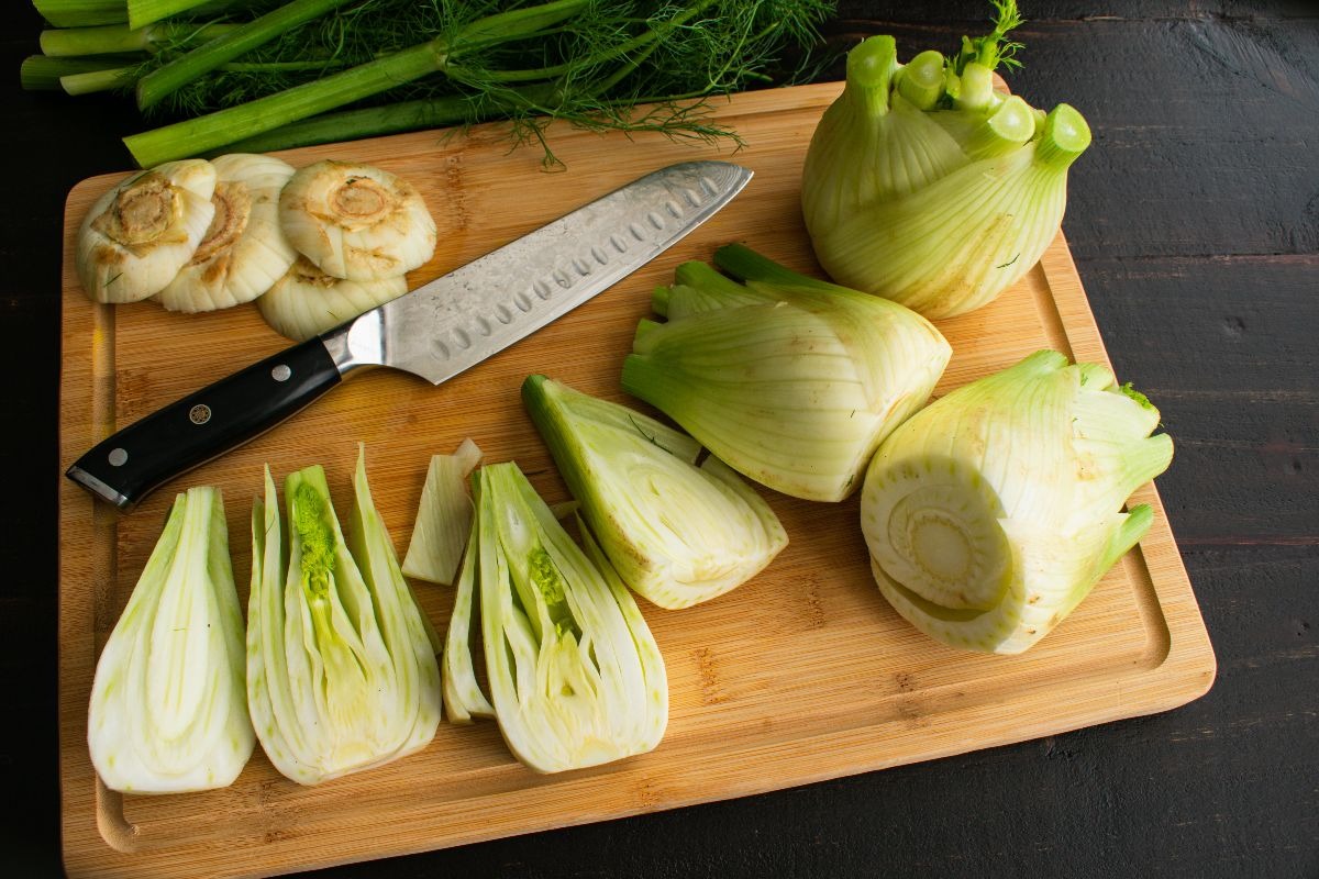 Tagliere di legno con finocchi tagliati a fette