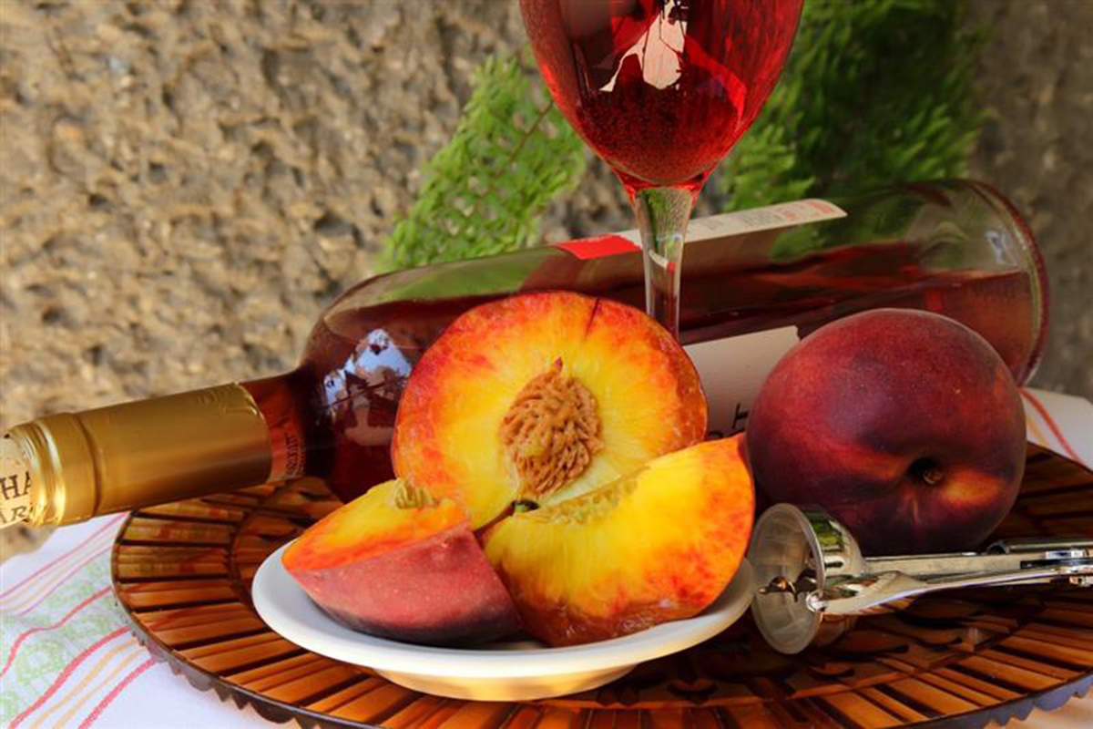 Pesche con vino in calice e in bottiglia