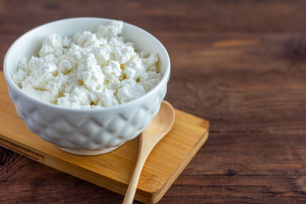 Ciotola con ricotta fresca e mestolo di legno