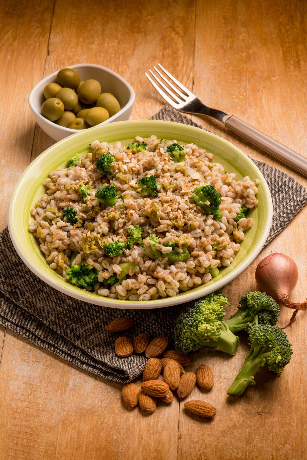 Piatto con insalata di farro con broccoli, mandorle, olive e tonno