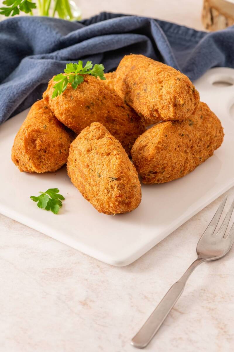 Polpette di baccalà su piatto bianco con forchettina