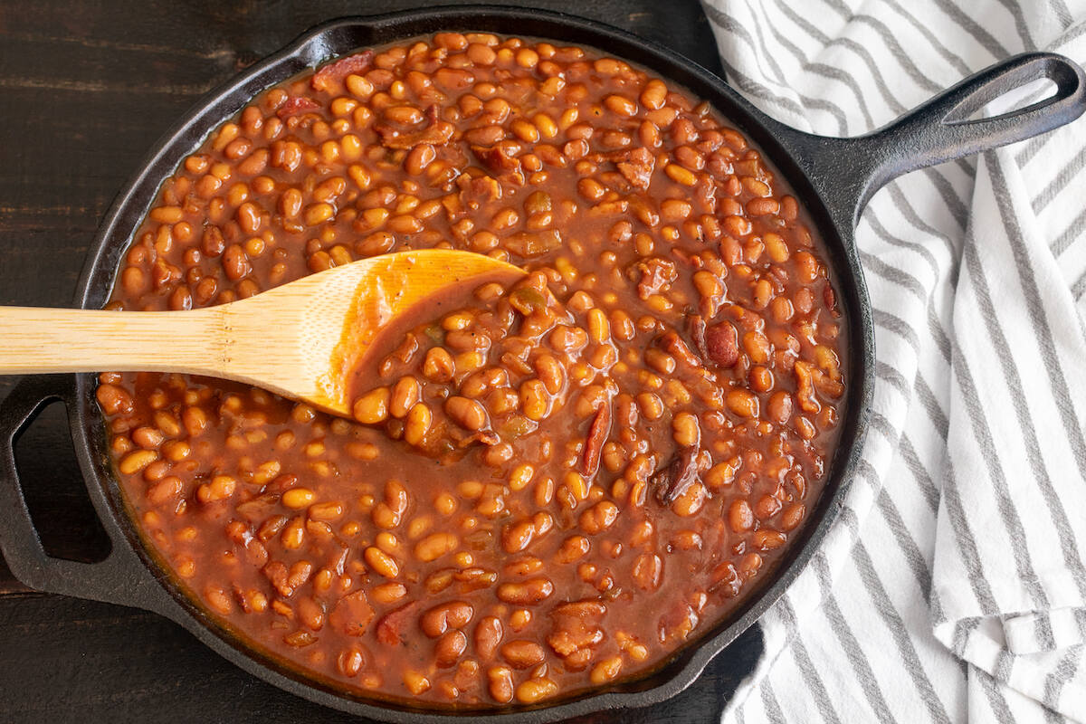 Padella in ghisa con fagioli cotti nel pomodoro con le cotiche