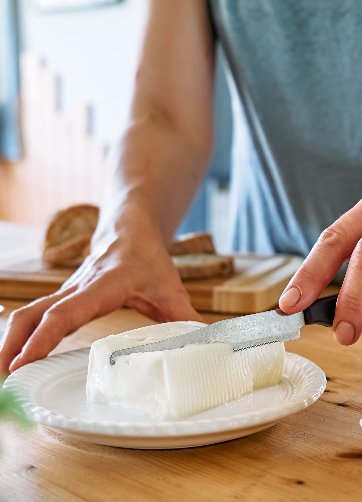 Mani di donna che prendono porzione di stracchino da piatto