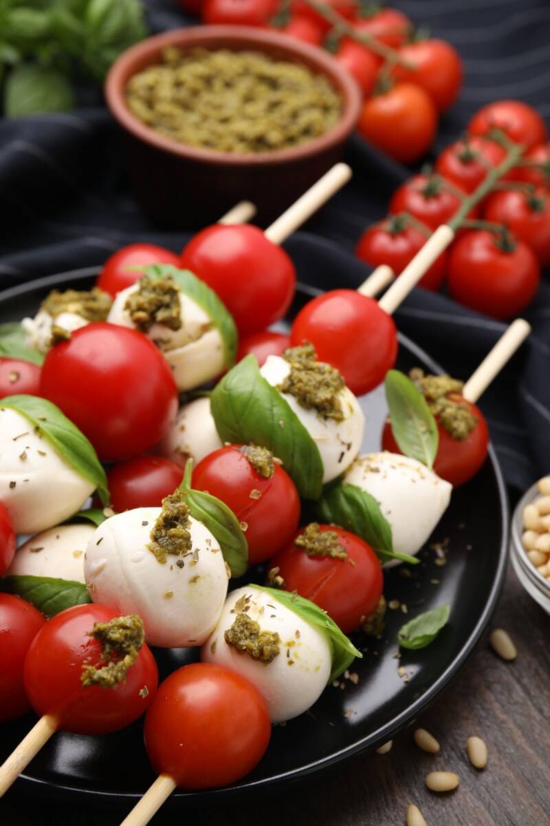 Piatto con spiedini di pomodorini, mozzarella e basilico con pesto
