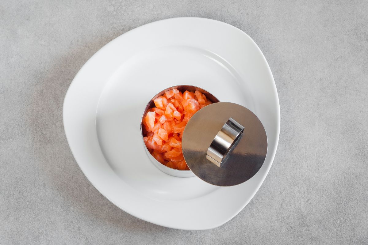 Vista dall'alto tartare di pesce in coppapasta di acciaio con coperchio