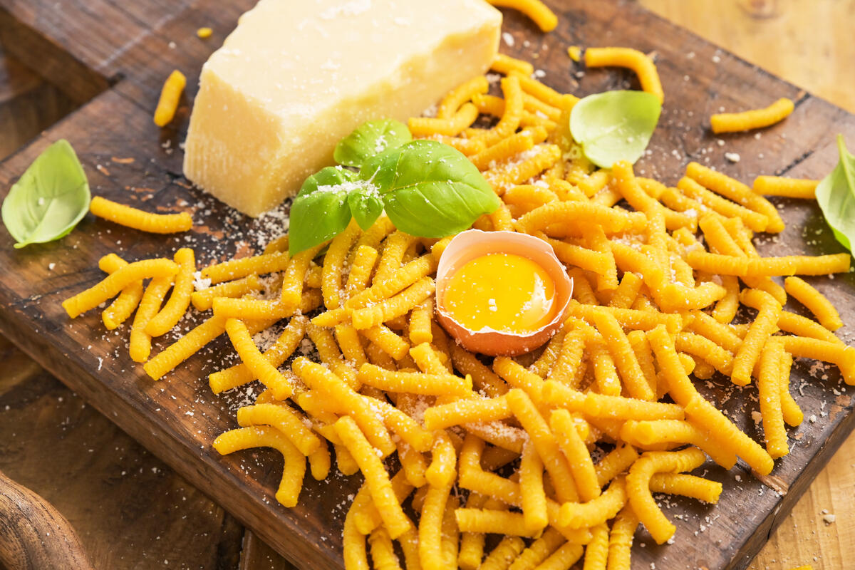 Tagliere di legno con passatelli appena fatti ancora da cuocere