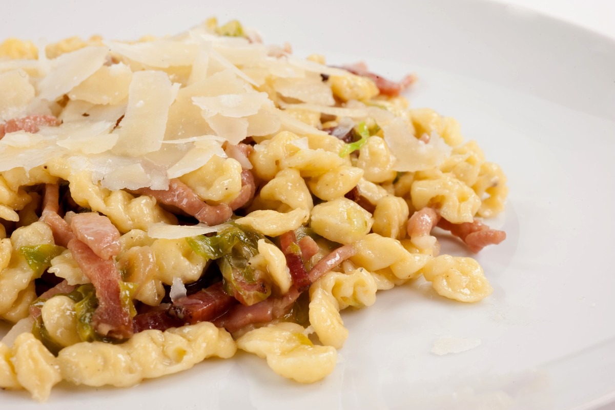 Piatto di spatzle conditi con speck e grana in scaglie