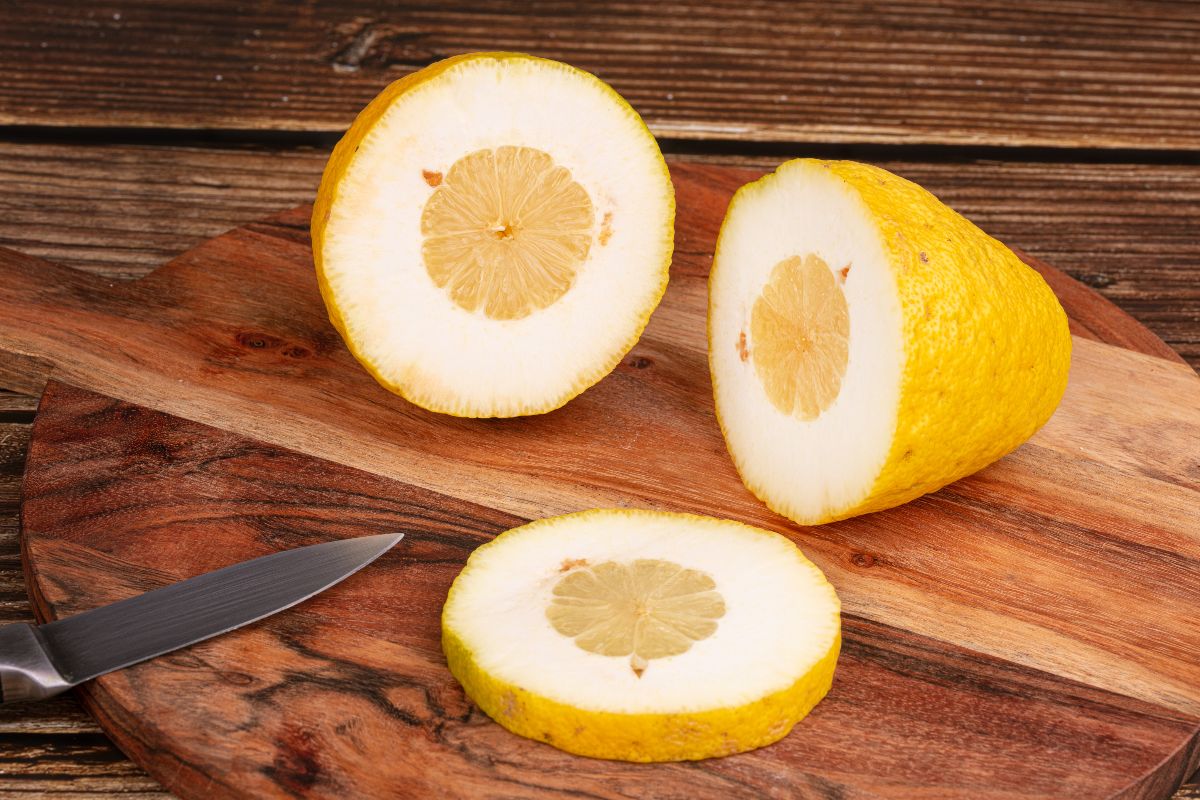 Cedro tagliato a metà con coltello su tagliere di legno