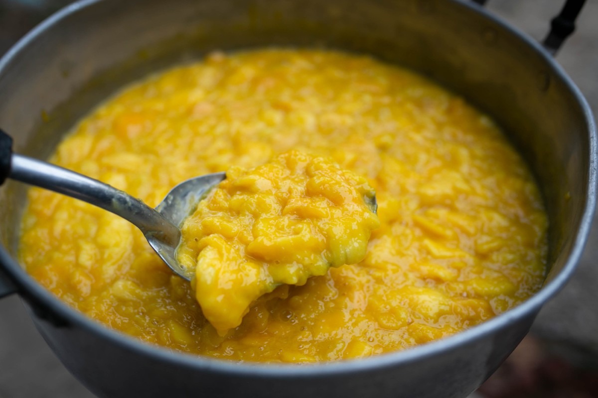 Cucchiaio che mostra consistenza marmellata di mango in cottura