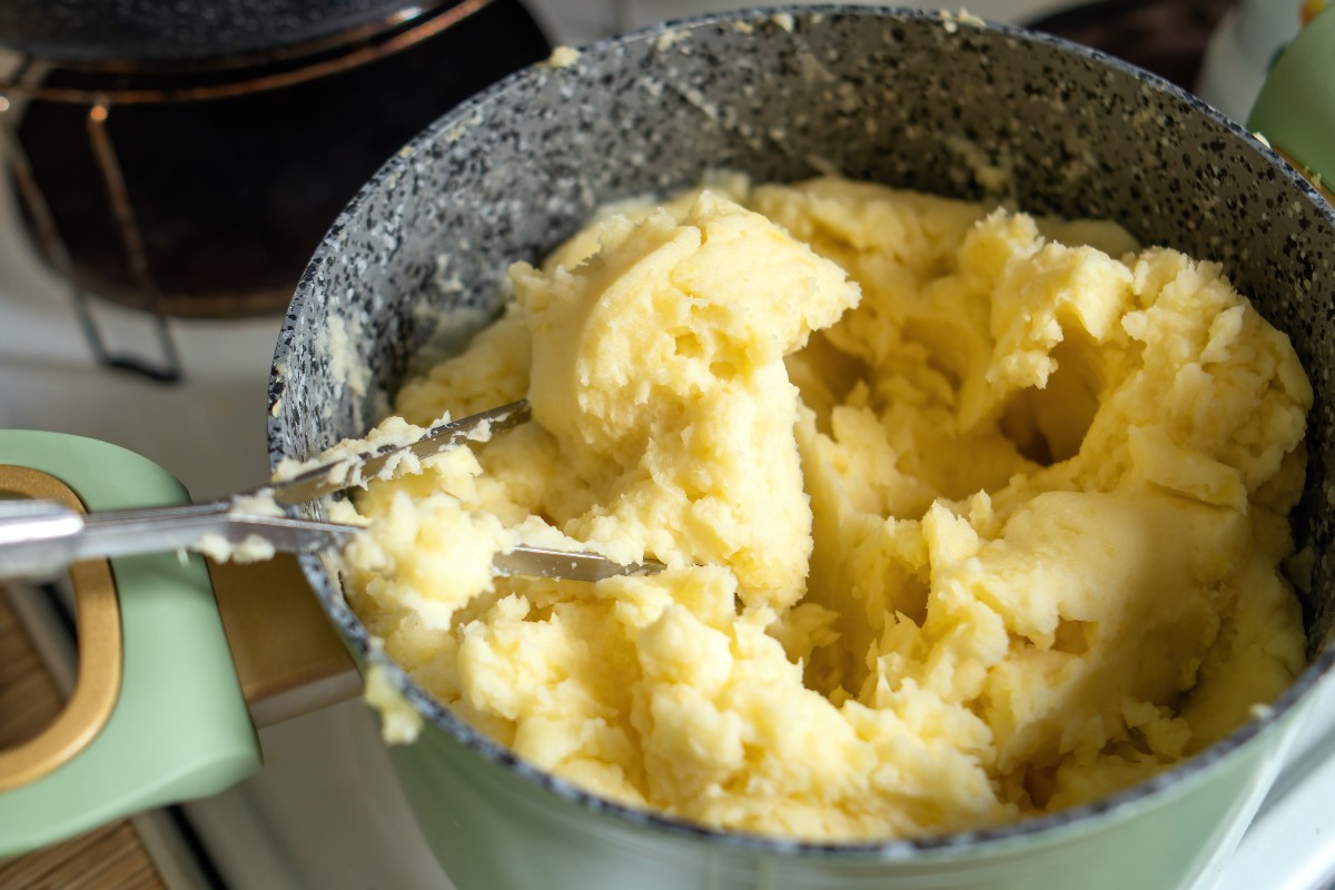 Patate schiacciate con apposito utensile all'interno di una pentola