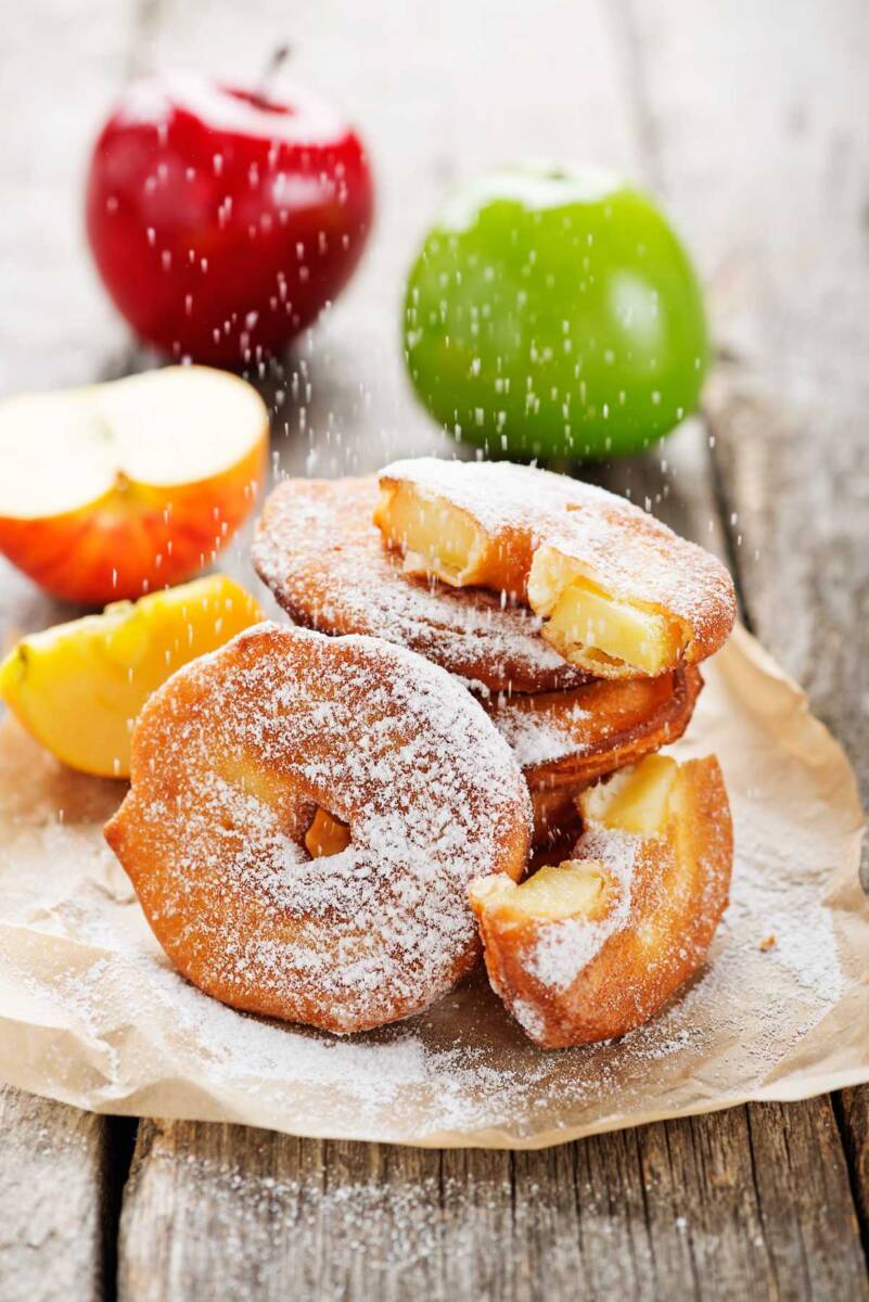 Mele tagliate ad anello e coperte di pastella decorate con zucchero a velo