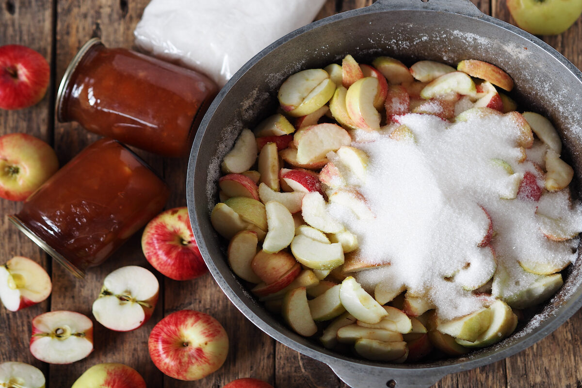 Mele e zucchero in pentola per preparare marmellata