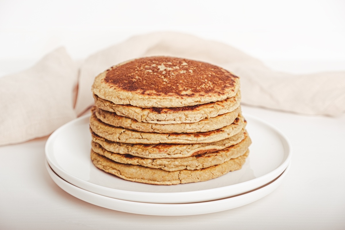 Pancake impilati uno sull'altro su piatto bianco
