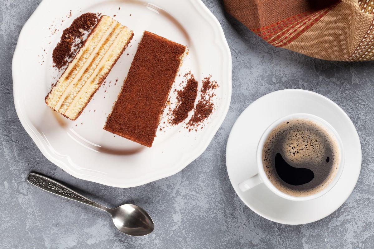 Vista dall'alto fette di torta a base di biscotti e crema a strati coperta da cacao in polvere