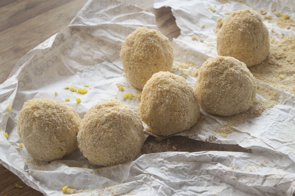 Arancini di riso rotondi passati nel pangrattato e pronti da cuocere