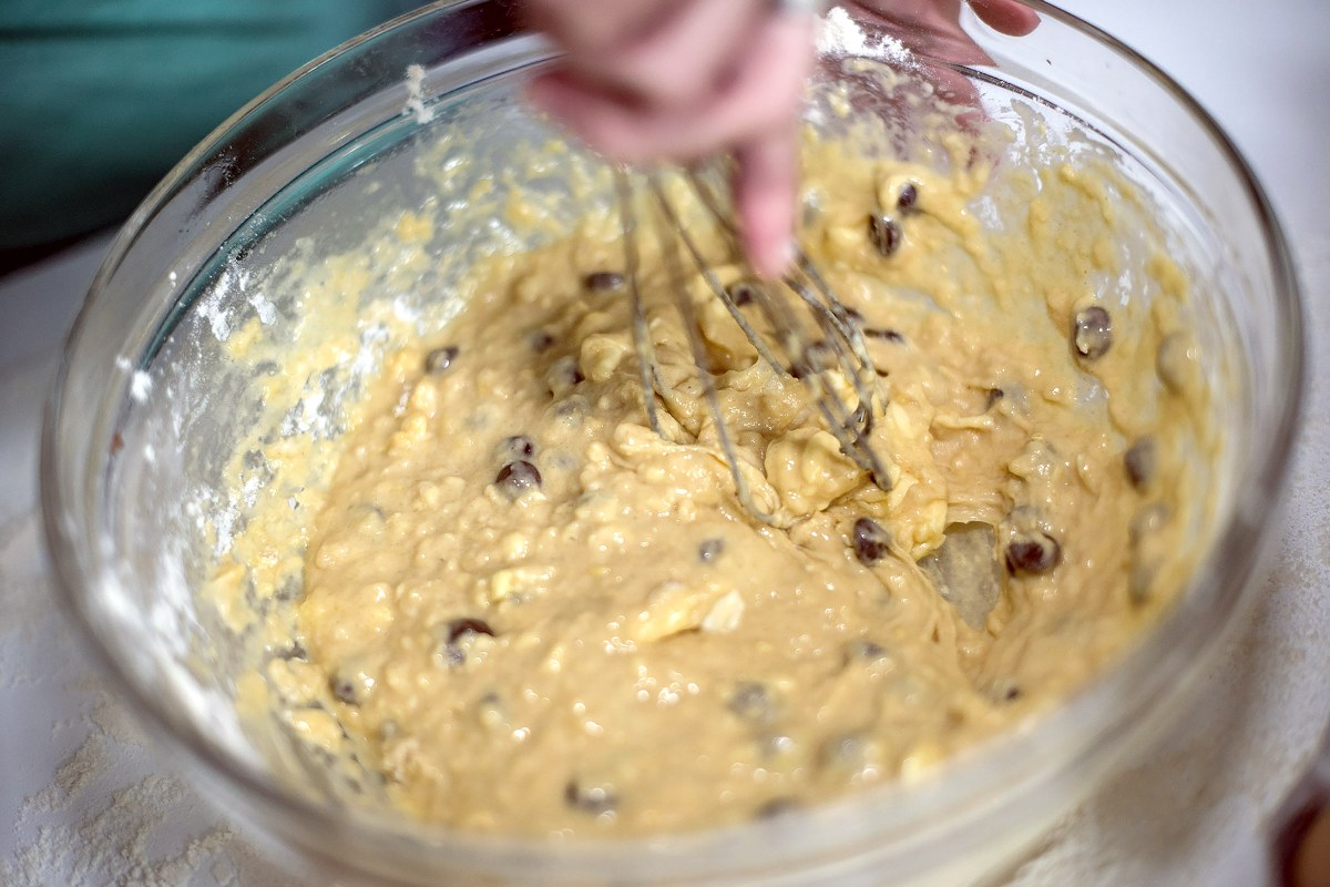 Impasto torta con gocce di cioccolato lavorata con frusta da cucina