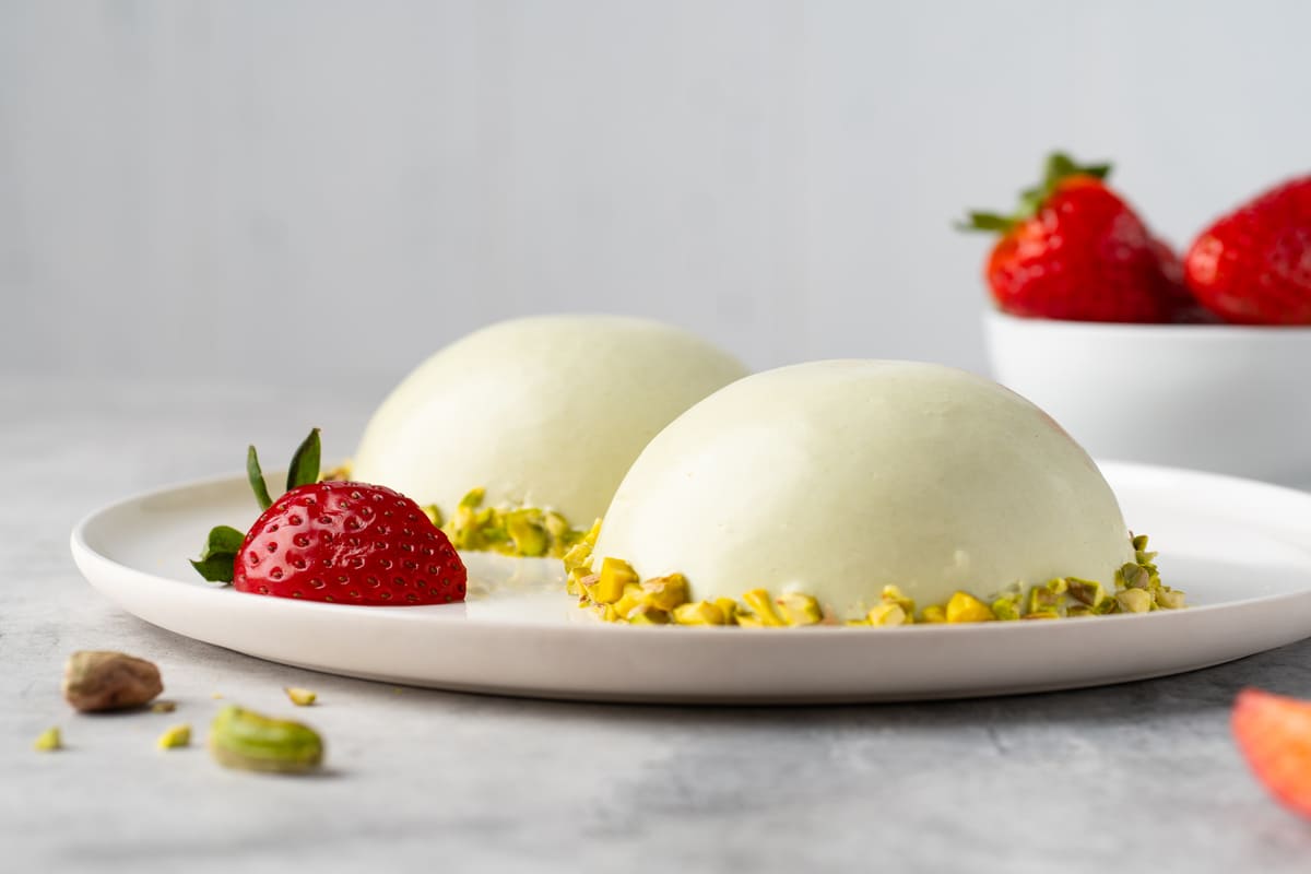 Cupolette di mousse al piastacchio decorate con fragole e granella di pistacchi