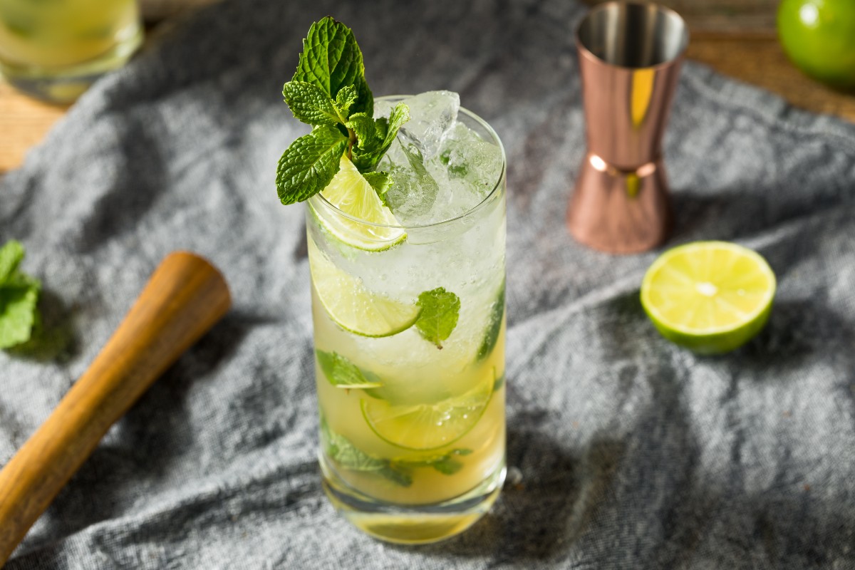 Bicchiere alto con cocktail trasparente e fette di lime