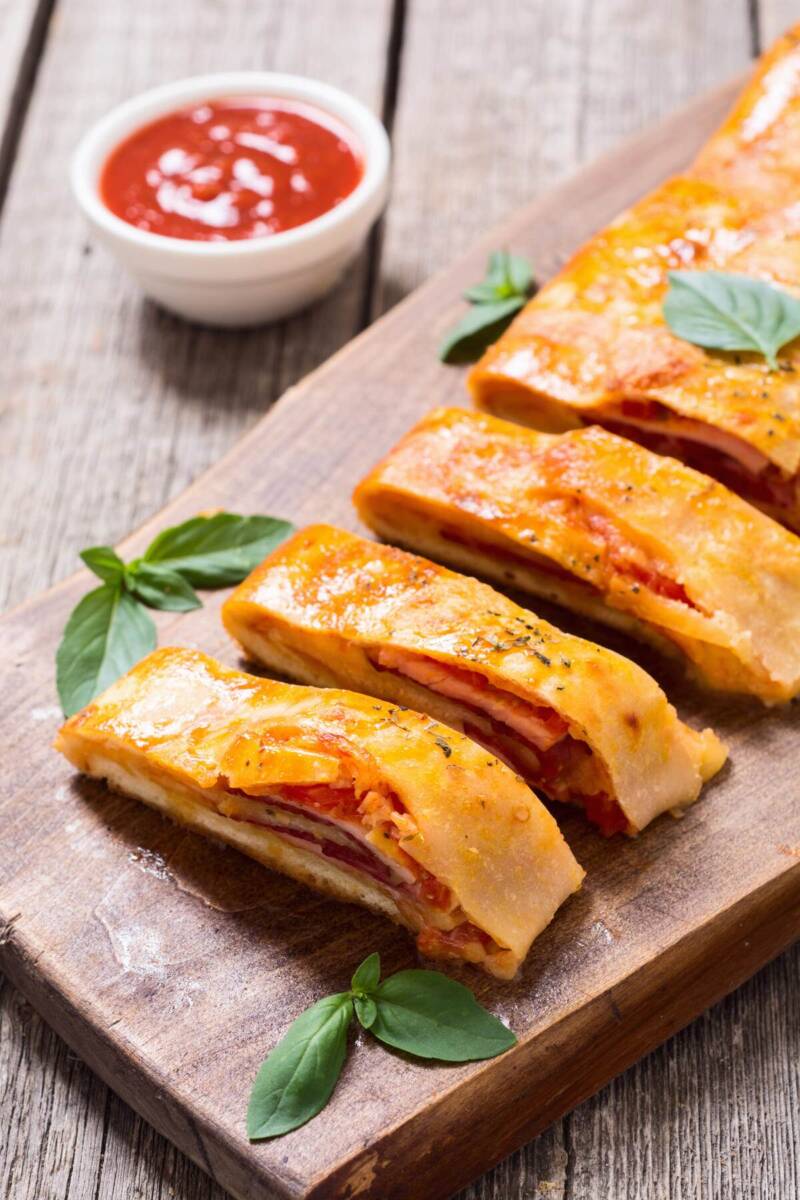 Rotolo di pasta sfoglia farcito con pomodoro, formaggio e prosciutto