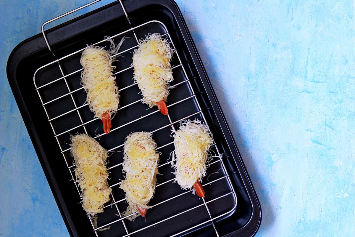 Gamberi avvolti in pasta kataifi su griglia di acciaio