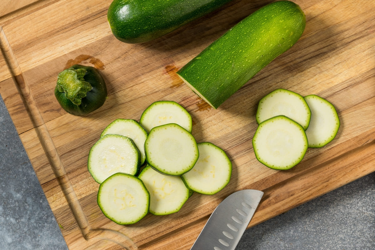 Zucchine tagliate a rondelle su tagliere di legno