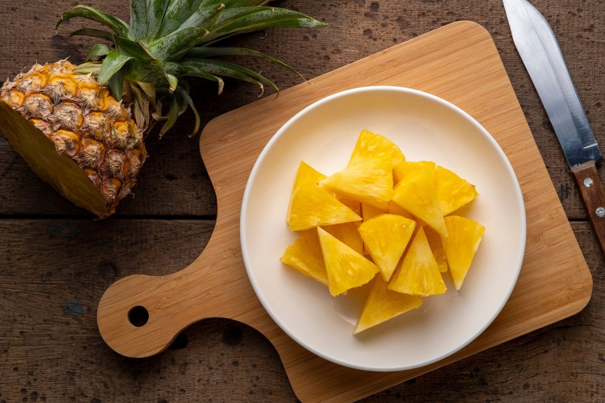 Vista dall'alto piatto con ananas fresco tagliato a pezzetti