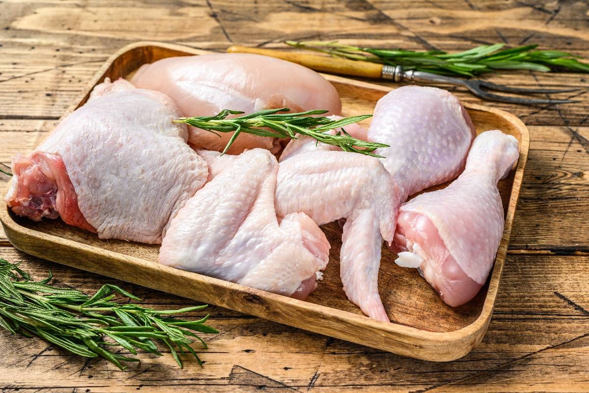 Pollo tagliato a pezzi nelle sue parti: alici, cosce, sovracosce e petto