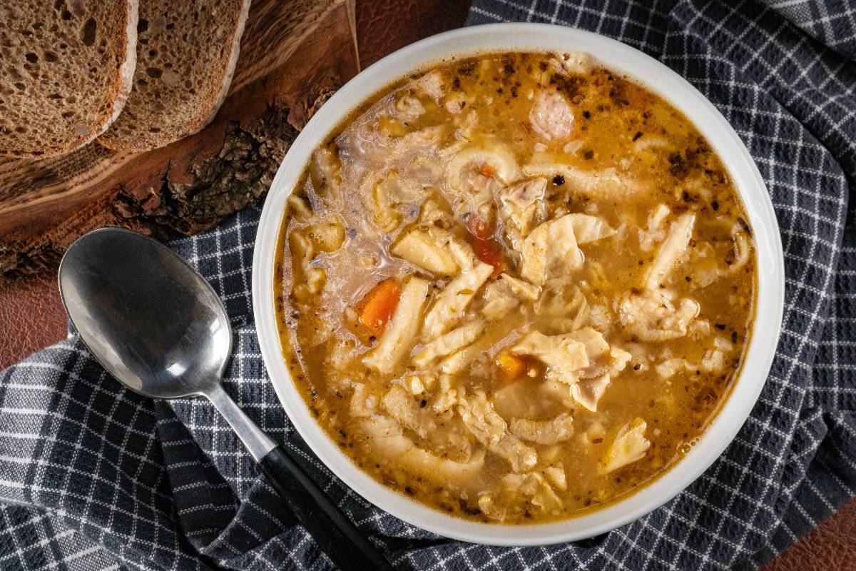 Vista dall'alto zuppa con pane, cipolle, carote e rigaglie