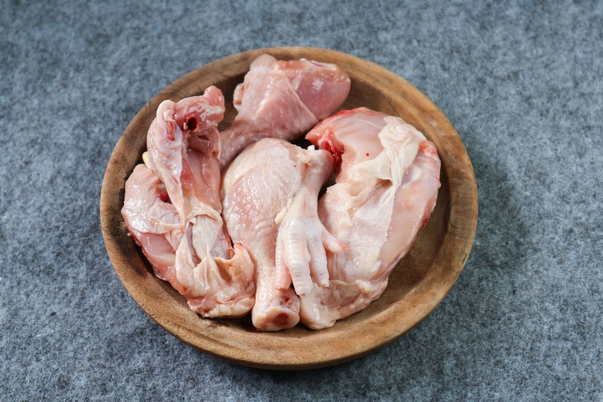 Ciotola di legno con carne di pollo a pezzi