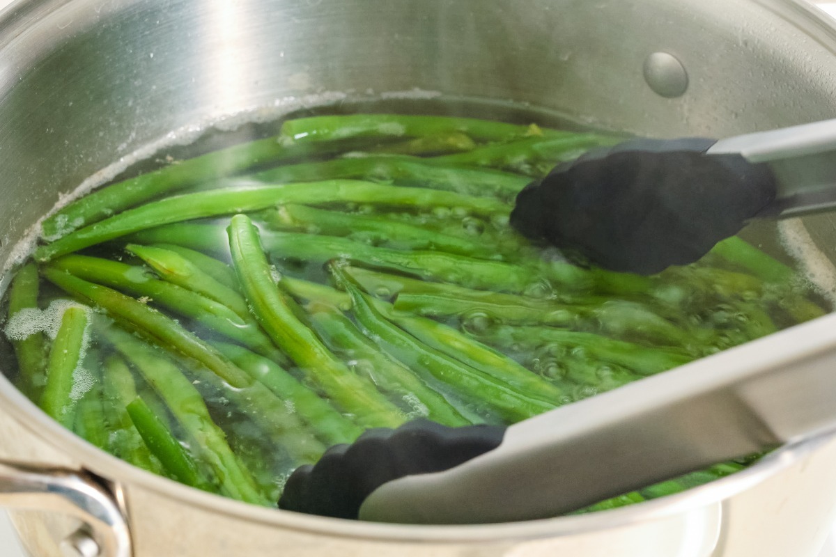 Pentola di acqua con fagiolini in cottura