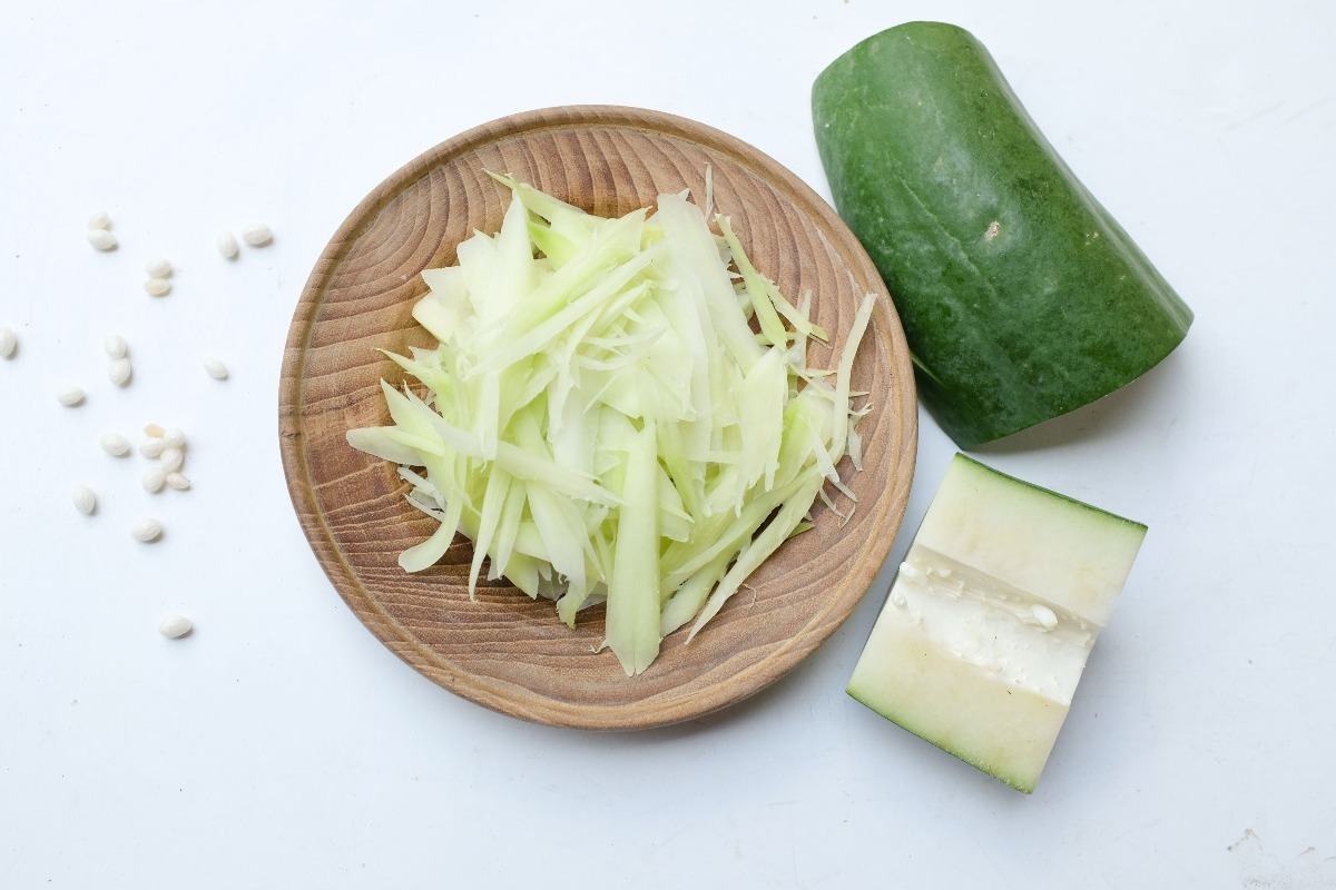 Vista dall'alto piatto in legno con papaya verde tagliata a julienne
