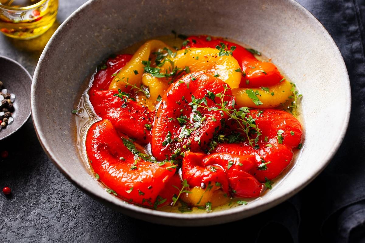 Ciotola con peperoni gialli e rossi arrosto conditi con origano