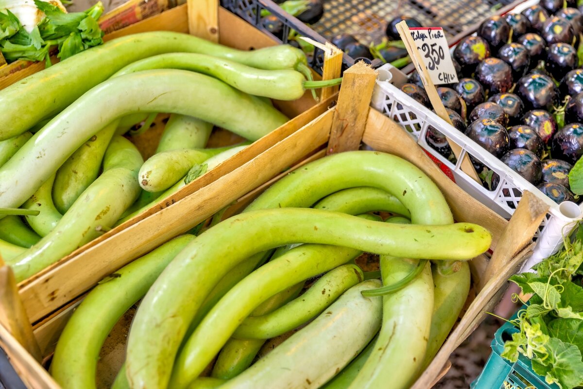 Cassetta di legno con zucchine lunghe siciliane