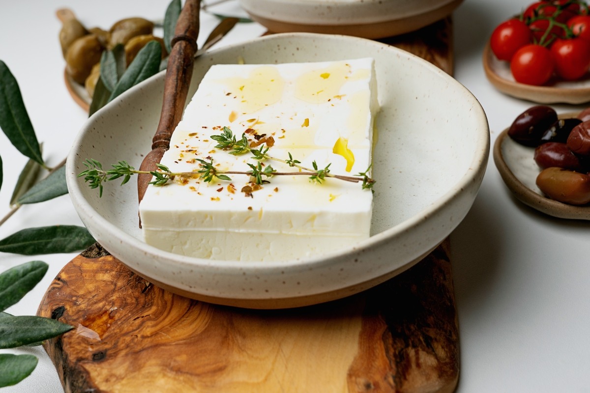 Piatto con feta greca e attorno olive, pomodorini, timo