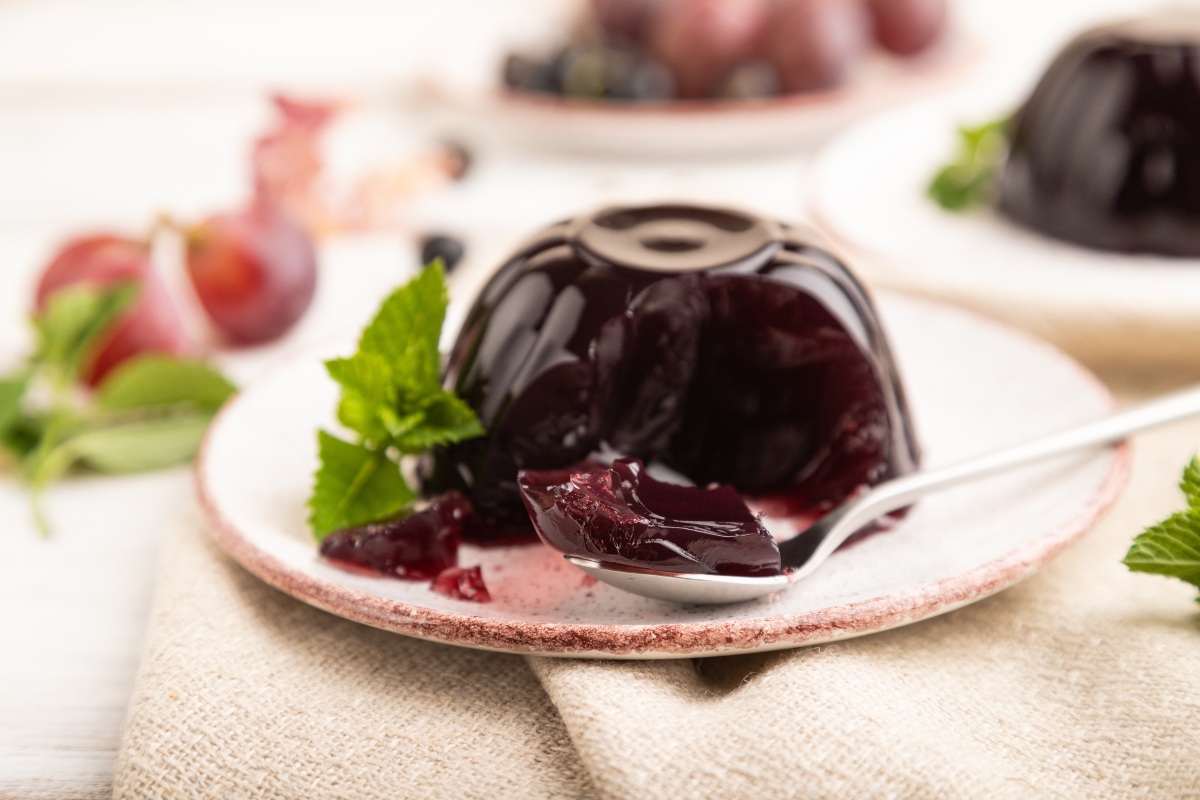 Gelatina di uva su piattino da dolce con cucchiaino
