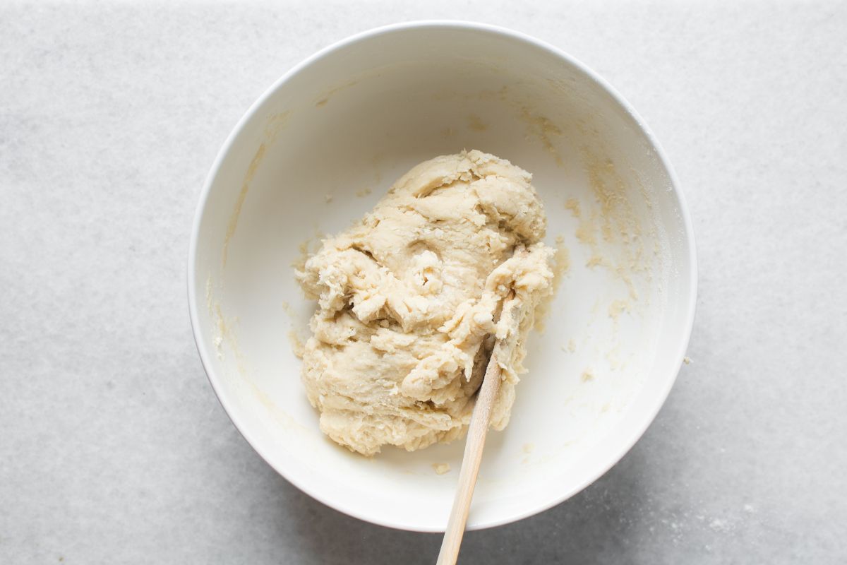 Vista dall'alto ciotola con impasto da mescolare e cucchiaio di legno