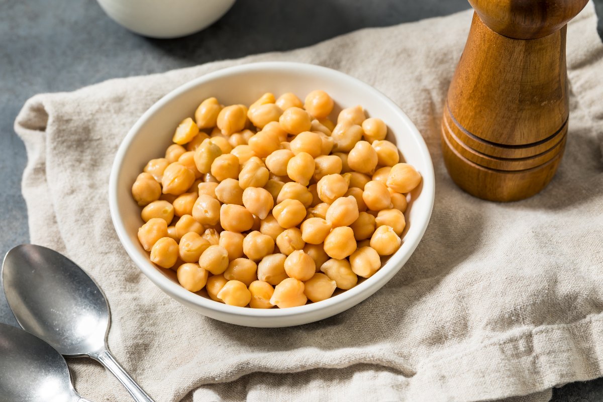 Piatto con ceci cotti con vicino macina pepe e cucchiaio 
