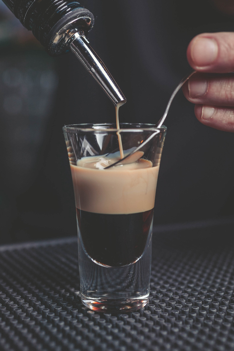 Preparazione cocktail B-52 versando Grand Marine su dorso del cucchiaio