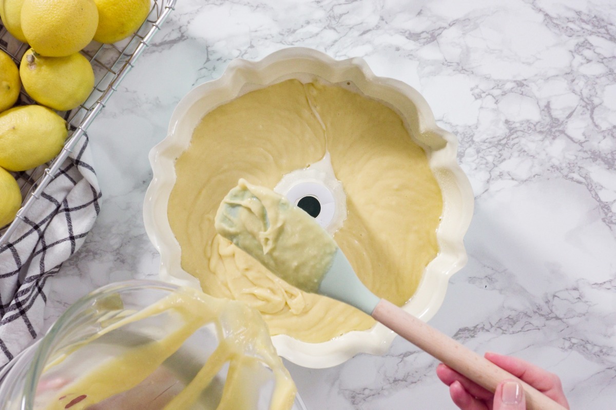 Impasto torta al limone che viene versato in uno stampo a ciambella