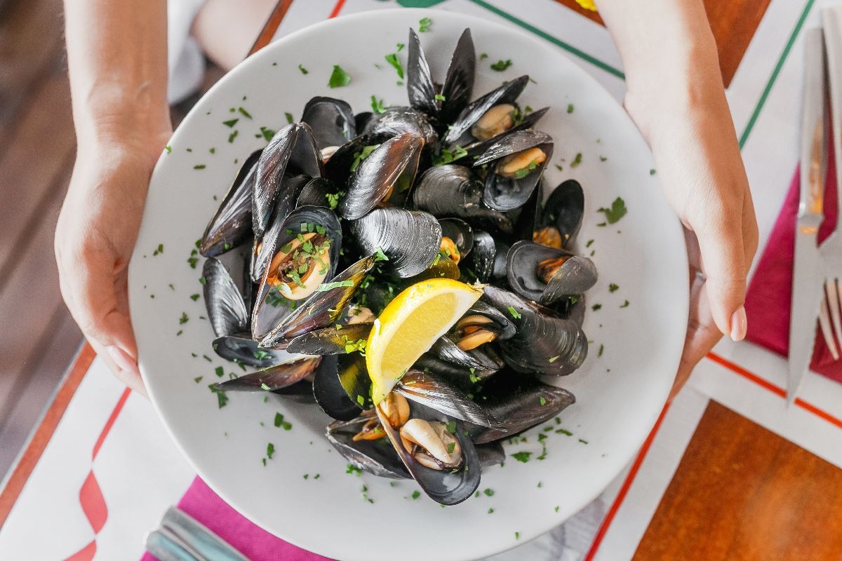Vista dall'alto piatto con cozze cotte e spicchio di limone