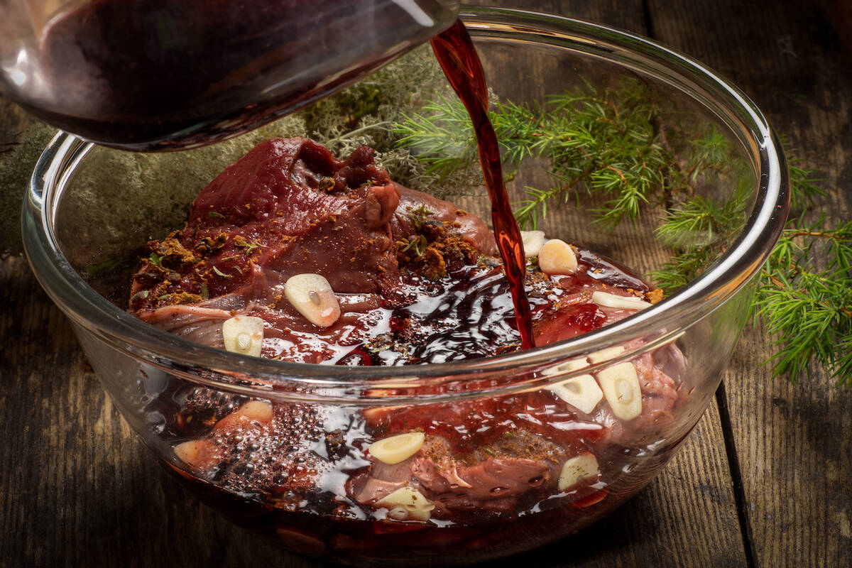 Vino rosso che viene versato sulla carne per marinarla