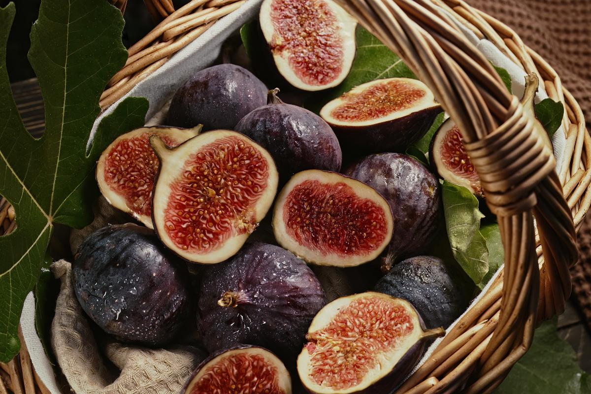 Cestino di fichi freschi appena raccolti alcuni tagliati a metà