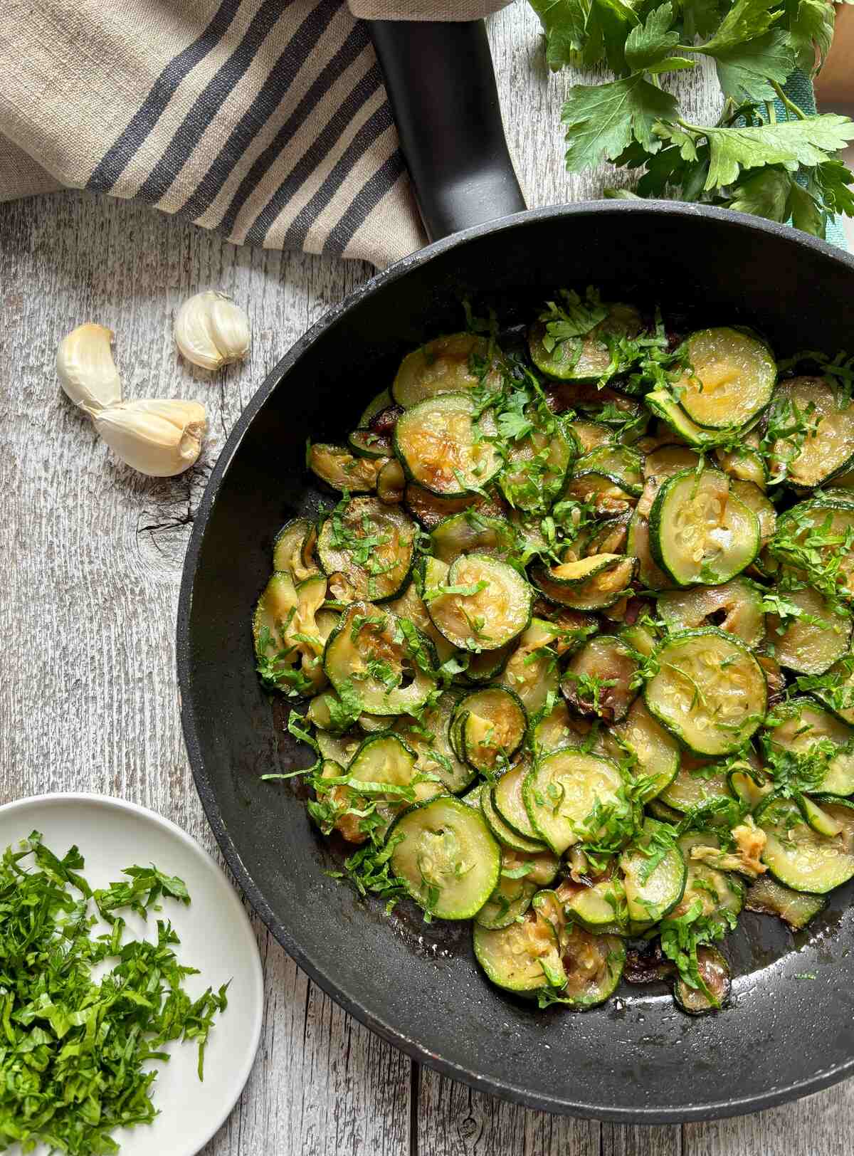 Vista dall'alto zucchine cotte in padella con prezzemolo e aglio