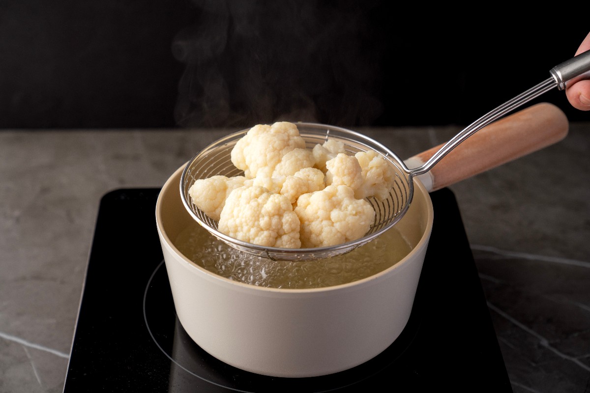 Cavolfiore sbianchito raccolto con schiumarola da pentola